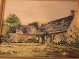 a painting of a house in a frame on the wall