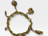a close up of a gold bracelet with charms on it