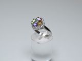 an image of a ring with multi colored stones on a clear glass