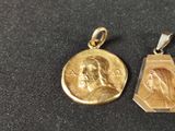two gold pendants of jesus and mary on a black background