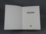 a white book with a black dog on it sitting on top of a table