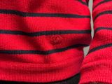 a close up of a person wearing a red and black striped sweater