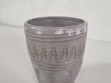 a close up of a gray cup on a white surface
