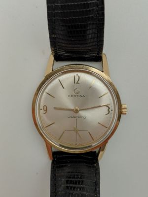 une image d'une montre-bracelet en or avec un bracelet en cuir noir