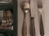 a lot of silverware on a table with a knife and fork