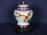 un vase orné d'un motif floral, posé sur un socle