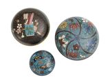 Trois types différents d'objets décoratifs sont exposés sur une surface blanche
