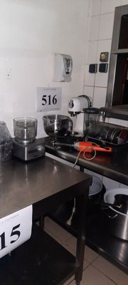 une photo d'une cuisine avec de nombreux ustensiles de cuisine posés sur le plan de travail