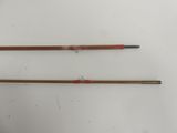two old fishing rods sitting on top of a white surface