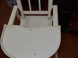 a white chair that is sitting on a brown floor