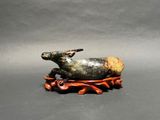 a figurine of a seal laying on a wooden base