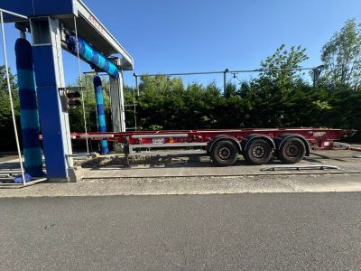 La remorque à plateau est garée devant une station-service