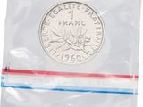 a close up of a coin in a plastic bag on a white background