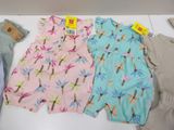 three pairs of baby clothes are on a table with a price tag