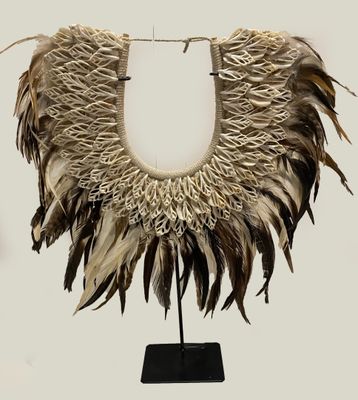 an image of a necklace made of feathers on a black stand