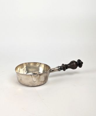 une casserole ancienne en argent avec un manche en bois, sur fond blanc
