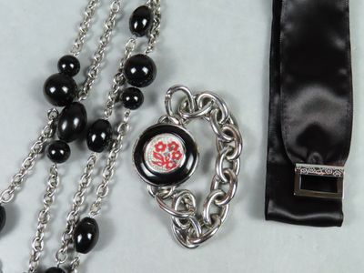 un collier noir et argent orné d'une fleur rouge