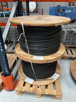 une pile de palettes en bois sur lesquelles sont posés des fils noirs