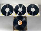 three black vinyl records sitting on top of a cardboard box