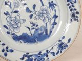 a blue and white plate with flowers and birds on it