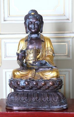 une statue de Bouddha assis sur une table rouge