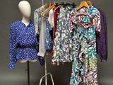 un mannequin debout à côté d'un présentoir de vêtements