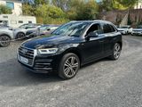a black audi suv parked in a parking lot next to other cars