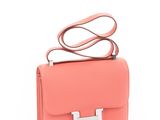 a small pink bag with a metal handle on a white background