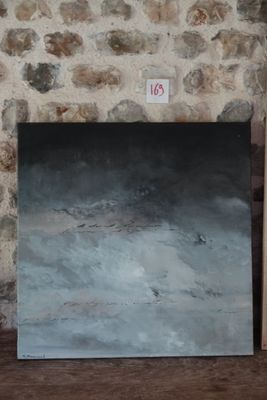 un tableau posé par terre, à côté d'un tableau accroché au mur
