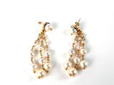 boucles d'oreilles en perles et en or sur fond blanc