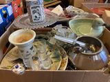 a cardboard box full of dishes and cups and saucers