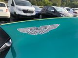 cars parked in a parking lot with a green car with a logo on the hood
