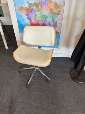 une chaise et une table dans une pièce où est accrochée une carte au mur