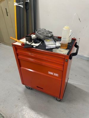 un petit chariot rouge sur lequel se trouvent de nombreux objets