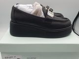 the black loafer is sitting on top of a box next to a pair of glasses