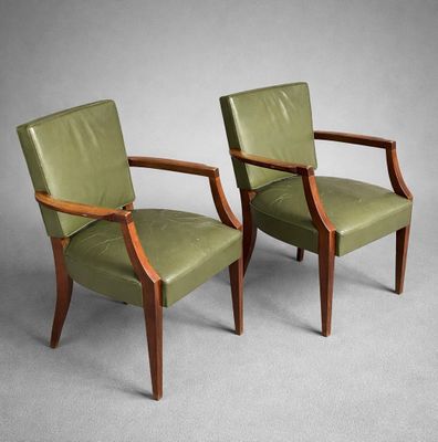deux fauteuils en cuir vert avec des accoudoirs en bois