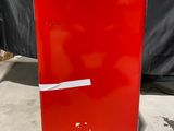 un réfrigérateur rouge posé à même le sol