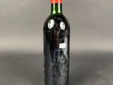 a black bottle with a red top on a table