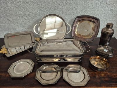 a lot of silver plated items on a wooden table