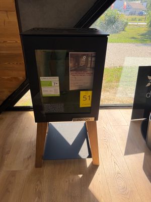 une boîte noire posée sur un socle en bois devant une fenêtre