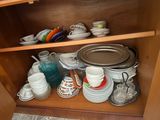de nombreuses assiettes et tasses sur l'étagère du placard