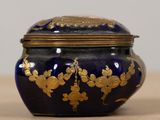 a blue and gold vase sitting on a table
