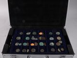 a silver case with coins in it on a white surface