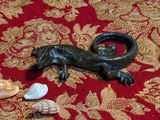 une photo d'une figurine de lézard posée sur un tapis rouge