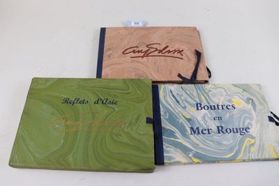trois livres posés sur une table blanche, l'un à côté de l'autre
