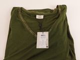 La chemise est verte et porte une étiquette blanche.