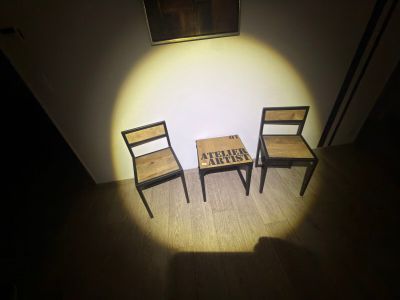 two chairs and a table in a room with a picture on the wall