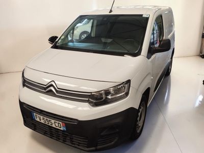 La camionnette blanche est garée dans la pièce blanche de l'immeuble.