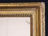 a mirror with a gold frame on a black wall