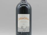 la bouteille de vin rouge est posée sur une surface blanche